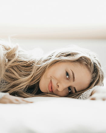 若い女性、 ベッドに横たわっています、 ほほえむ、 長いブロンドの髪、 屋内でリラックスします、 平穏、 暖かさ、 屋内リラクゼーション、 平穏な瞬間、 居心地の良い雰囲気、 自然の美