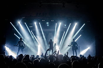 live concert, stage performance, singer, guitar player, bass player, vibrant lighting, crowd engagement, energetic music, musicians on stage, concert atmosphere, stage lights