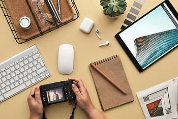 persona che tiene la fotocamera, Spazio di lavoro moderno, Gadget tecnologici, vista dall'alto, telecamera, bloc notes, tastiera, topo, tavoletta, impostazione dello spazio di lavoro, disposizione della scrivania