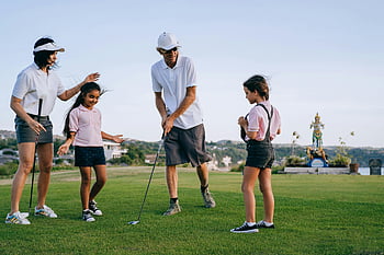 familie spiller golf, solskinsdag, Kvalitetstid udendørs, golfbane, familieaktivitet, friluftsliv, Golfklub, grønt græs, familie bonding, Golfantøj, golf swing