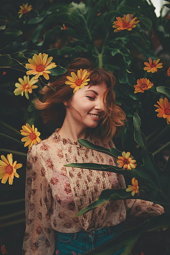 woman in pink floral shirt, vibrant yellow flowers, serene outdoor portrait, young woman smiling, floral dress, outdoor photography, natural beauty, floral background, garden portrait, floral fashion, yellow flower garden