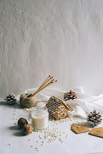 Christmas decors, winter background, cozy gingerbread house, pine cones, candle, holiday warmth, festive scene, winter decor, gingerbread decoration, seasonal decor, cozy atmosphere