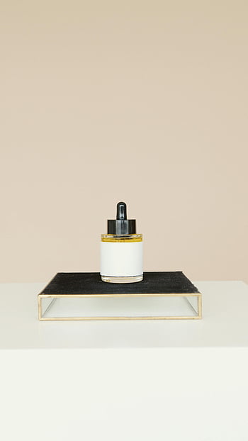 cosmetic product, skincare product, black stand, neutral background, elegant design, beauty product, glass container, dropper bottle, minimalist aesthetic, luxury skincare, modern design