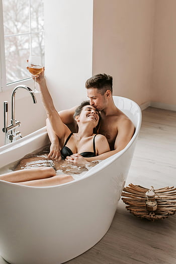 couple in bathtub, relaxing bath, romantic moment, sharing wine, happy couple, bathtub with water, romantic bath, couple enjoying bath, intimate moment, cozy bath, bath time