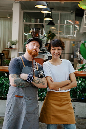 baristas, coffee shop, coworkers, teamwork, hospitality, trendy cafe, street cafe, smiling baristas, apron, coffee beans, coffee machine