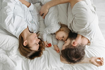 family bonding, lying on bed, father mother daughter, family moments, bed together, family embrace, family photo, family time, family love, family happiness, family togetherness