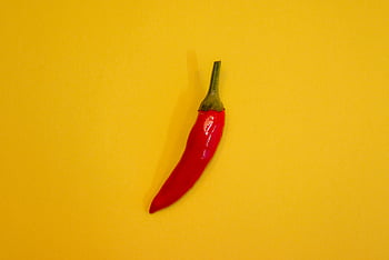red chili, yellow surface, vibrant yellow, single chili, fresh chili, spicy food, red pepper, yellow background, isolated chili, chili pepper, freshness