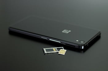 black smartphone, black table top, SIM card, memory card, modern technology, close-up, smartphone technology, black surface, tech accessories, mobile device, digital storage