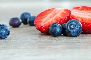 strawberries, blueberries, sliced strawberries, wooden surface, fresh fruit, close-up, brown surface, healthy food, fruit photography, food photography, natural ingredients