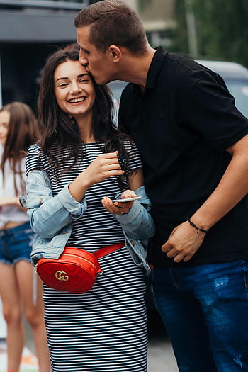 man kissing woman's forehead, smiling couple, affectionate moment, outdoors, couple, love, romance, street, casual, happiness, affection