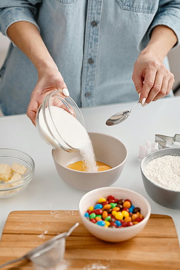flormelis, Blanding af ingredienser, Hjemmelavet dessert, Farverige slik, skål, ske, bagning, køkken, tæt på, person hælder, sukker