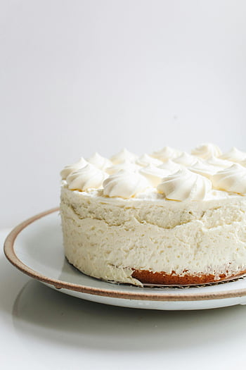 white cake, vanilla cream cake, whipped topping, ceramic plate, mouth-watering dessert, white frosting, creamy cake, dessert photography, cake on plate, vanilla cake, whipped cream cake