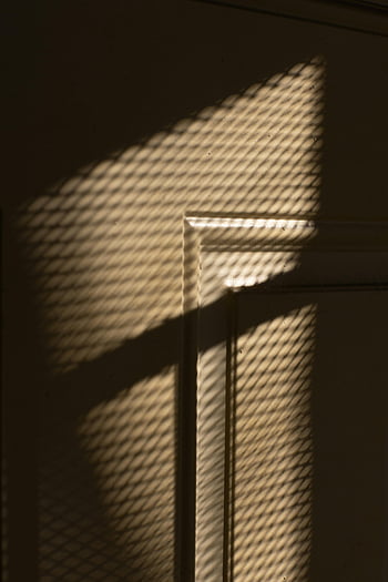 bej perete, Umbre net ale ferestrei, modele de umbra, Lumina prin suprafața texturată, Umbre interioare, perete texturate, Net fereastră, lumină și umbră, iluminat interior, umbre de perete, umbre intrigante