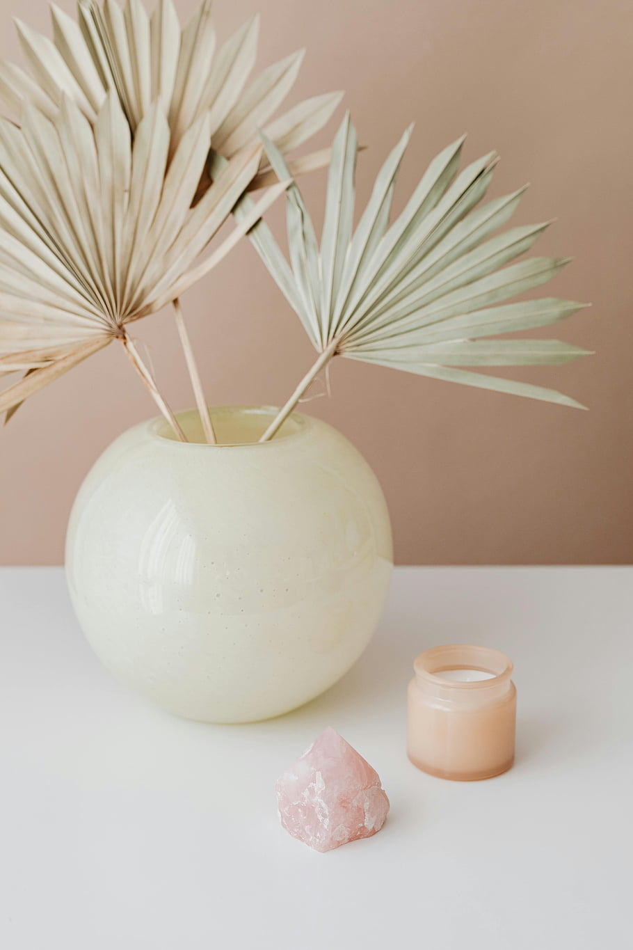 minimalistický dekor, Nahý domácí interiér, Stylová váza, sušené palmové listy, svíčka, bílý povrch, pastelové barvy, Moderní estetika, domácí výzdoba, Vzhled interiéru, přírodní prvky