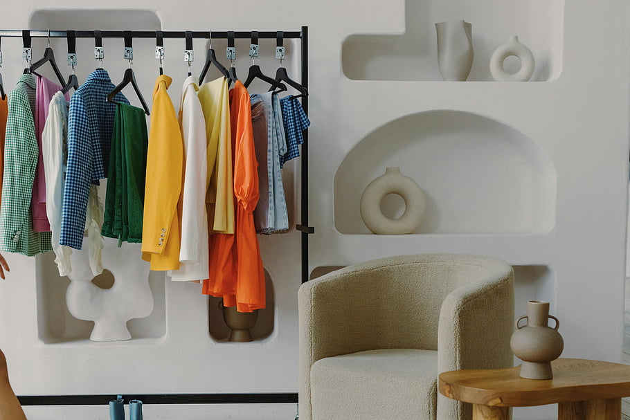 clothes hanging, clothing rack, colorful clothes, contemporary room, artistic decor, indoor fashion, modern interior, stylish wardrobe, fashion display, home decor, vibrant clothing