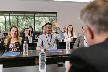 business conference, young man, raising hand, businesspeople, conference room, discussion, professional setting, meeting, audience engagement, corporate event, networking