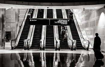 terminal do aeroporto, escadas rolantes, Viajantes, aeroporto moderno, Sinais direcionais, fotografia em tons de cinza, mulher andando, escada, Preto e branco, viagem, terminal
