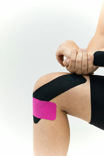 ταινία Kinesio, θεραπεία γόνατος, ιατρική φροντίδα, kinesio taping, υποστήριξη γόνατος, φυσική θεραπεία, αθλητικό τραυματισμό, ανάκτηση, Αναμόρφωση, λευκό φόντο, φροντίδα υγείας