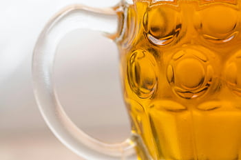 amber beer, textured glass mug, closeup photo, refreshing beverage, glass mug, close-up view, amber beverage, textured mug, beer mug, glassware, refreshing drink