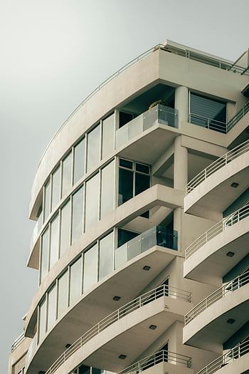 Modernes Wohngebäude, Schlanke Fassade, gebogene Fassade, große Fenster, zeitgenössische Architektur, städtischer Wohnungsbau, modernes Design, Wohnarchitektur, Wohngebäude, geschwungenes Gebäude, Glasfenster