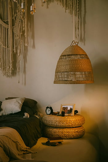 ložnice v boho stylu, proutěný dekor, Útulné osvětlení, texturované textilie, závěsná lampa, stolek, vřelá atmosféra, Hangování stěny makrame, Bohémský interiér, proutěné stínící lampy, noční stolek