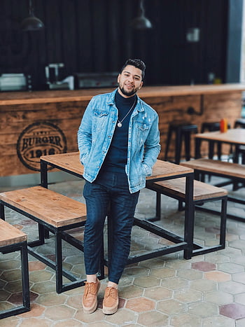 pánská modrá džínová bunda, Náhodný mladý muž, Moderní městská restaurace, džínové bundy, Neformální outfit, městském prostředí, interiér restaurace, stylová pánská móda, Pánská móda, příležitostná pozice, Moderní restaurace