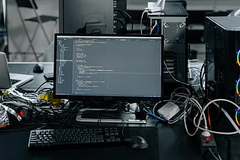 workstation computer, monitor, HTML editor, cluttered workstation, office, code display, keyboard, mouse, wiring, desk setup, programming environment