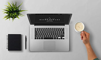 man using laptop, minimalist workspace, grey desk, coffee cup, notebook, white background, desk setup, laptop on table, workspace design, plant decoration, top view workspace