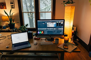 Moderno lavoro di lavoro, stanza accogliente, luce soffusa, Configurazione dell'ufficio di casa, il computer portatile, tenere sotto controllo, illuminazione calda, lavoro a distanza, gadget, piante, impostazione della scrivania