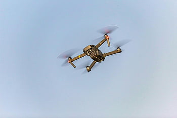 flying drone, aerial view, drone in motion, blue sky, modern technology, drone photography, unmanned aerial vehicle, UAV, drone flight, drone technology, aerial drone
