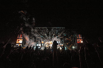 concierto en vivo, concierto nocturno, actuaciones energéticas, multitud entusiasta, concierto vibrante, escenario de concierto, vitoreo de la multitud, Ambiente de concierto, concierto al aire libre, iluminación de conciertos, explosión de confeti