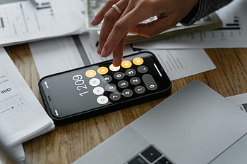 Mann mit Ehering, Mobiler App -Rechner, Finanzberechnungen, Smartphone -Taschenrechner, Nahaufnahmefoto, Dokumente auf der Tabelle, finanzielle Planung, Mobile Finanz -App, Persönliche Finanzen, Finanzverwaltung, Mobile Calculator App