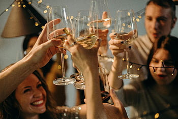 selective focus, people cheering, wine glasses, festive celebration, champagne glasses, group of friends, joyful toasting, party atmosphere, celebration moment, social gathering, holiday celebration