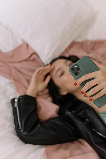 žena, lůžko, selfie, chytrý telefon, kožená bunda, vleže, Ležérní styl, Vnitřní nastavení, osobní okamžik, uvolněná atmosféra, využití technologie