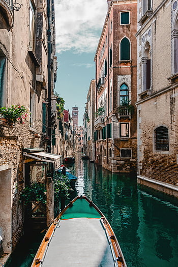 Venetian canal, historic buildings, travel enthusiasts, traditional Venetian, man-made river, gray and brown boat, captivating view, travel photography, Venice Italy, canal scene, gondola boat