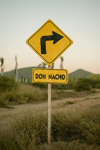caution, yellow road sign, arrow, Don Nacho, desert landscape, sunset, outdoor scene, directional sign, natural setting, travel destination, scenic view