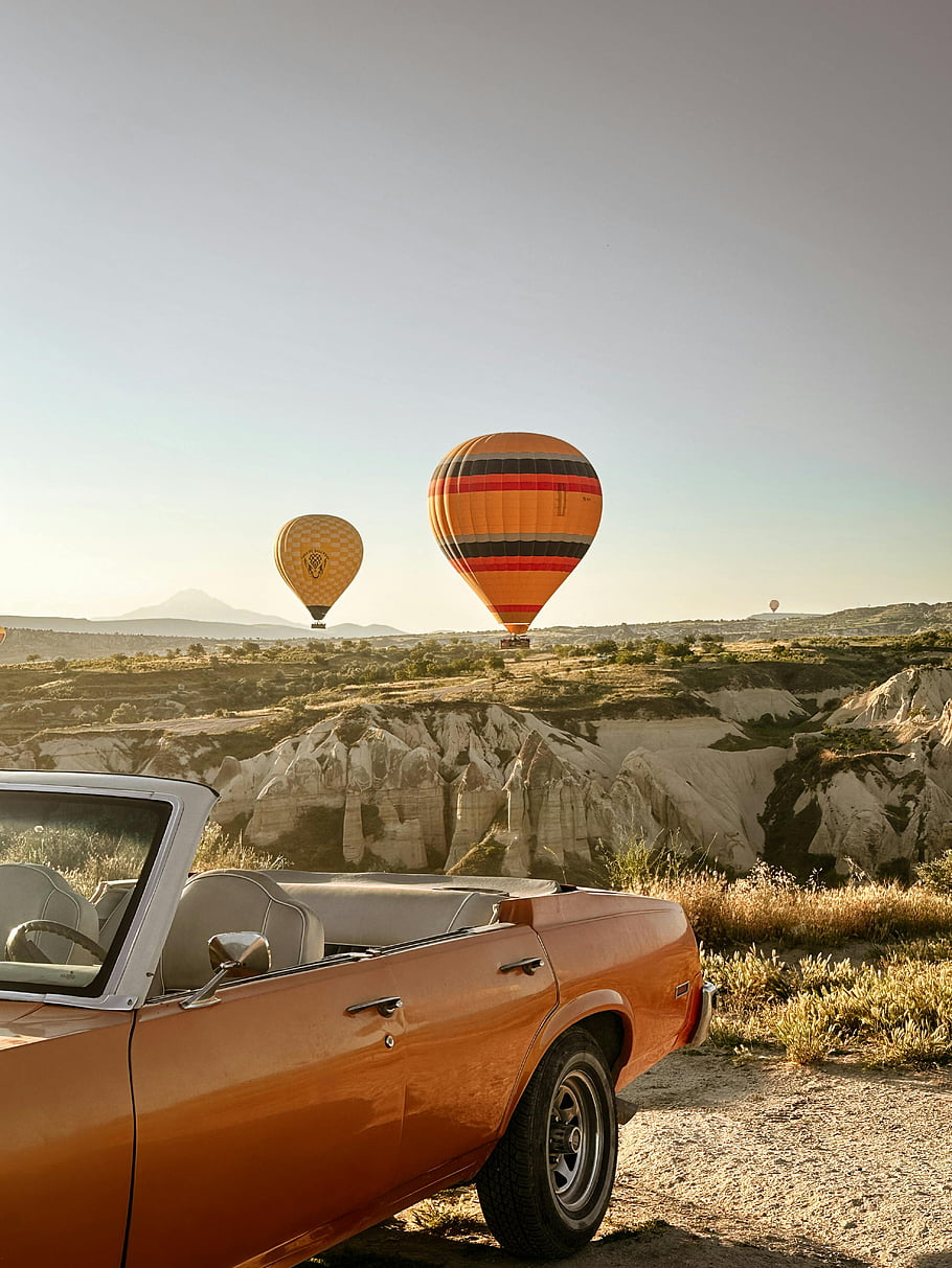 Balón přes poušť, klasické auto, barevné balónky, Krajina Cappadokia, svítání, horkovzdušné balóny, jedinečná krajina, pouštní scenérie, Historické auto, cestovní fotografie, dobrodružné cestování