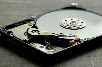 hard disk drive, black and silver, disk platter, actuator arm, detailed view, open hard drive, storage device, computer hardware, internal components, data storage, magnetic disk