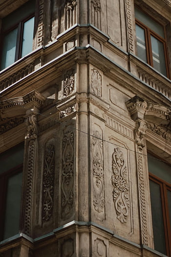 dekorativní basreliéfy, Historická fasáda budovy, Složitý architektonický design, elegantní basreliéfy, Detailní architektura, zdobené detaily budovy, historické architektury, detaily fasády, architektonické prvky, výzdoba budov, Historická fasáda