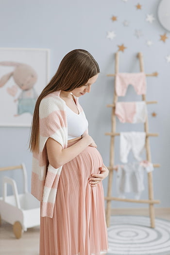těhotná žena, dítě narazit, růžová sukně, klidná školka, pohladit břicho, těhotenská móda, výzdoba školky, Těhotenské focení, nastávající matka, miminko, těhotenský styl