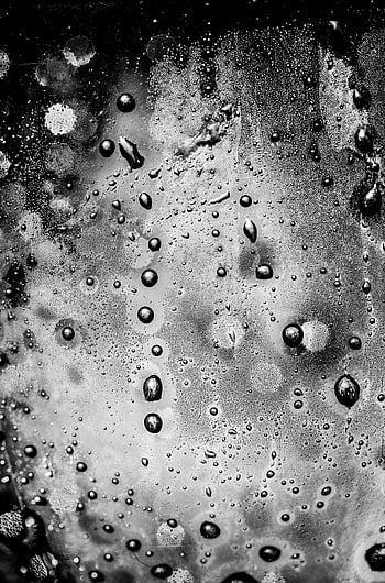 water droplets, glass panel, abstract close-up, monochrome, moody ambiance, black and white, texture, bubbles, surface, artistic, photography