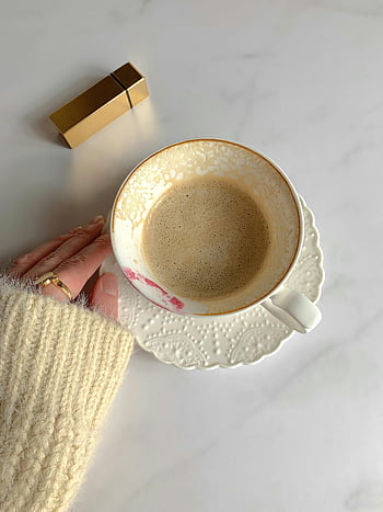 caffè, tavolo bianco, tazza di ceramica, scena accogliente, maglione, segno di rossetto, caffè del mattino, marmo bianco, rossetto d'oro, tazza di caffè, piattino bianco
