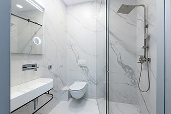 Weißes Marmorbad, schlanke Dusche, Toilette, sinken, Edelstahldusche, elegantes Badezimmer, modernes Badezimmer, Marmorfliesen, Glasdusche, Weißes Badezimmer