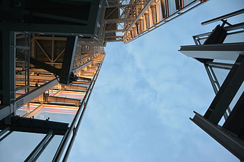 high-rise building, low angle photography, modern steel structure, daytime, sky, architecture, urban, cityscape, building exterior, structural design, steel construction