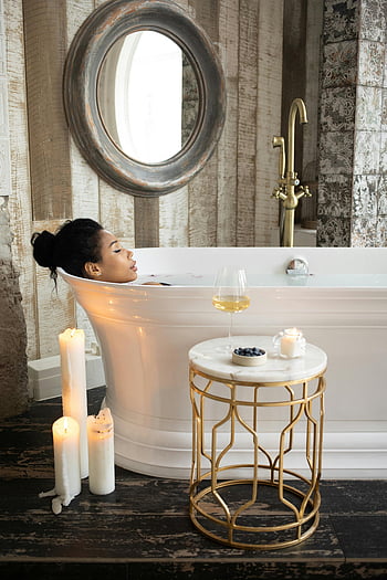 ethnic woman, bathtub, bathroom, candles, glass of wine, spa-like ambiance, relaxing, tranquil scene, bath time, luxury bathroom, self-care