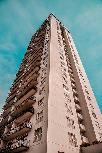 fotografía de bajo ángulo, hormigón marrón, edificio alto, arquitectura moderna, cielo azul claro, paisaje urbano, edificio residencial, diseño exterior, estructura vertical, vista de rascacielos