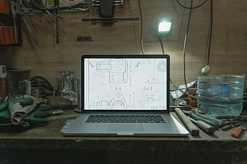 laptop, blueprints, workbench, workshop, cluttered, tools, blueprint design, work table, workshop setting, technical drawing, computer screen