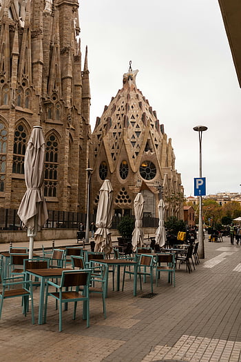 sagrada família, barcelona, gotisk arkitektur, historisk kirke, sitteområde, ikoniske elementer, gatevisning, majestetisk bygning, Utendørsbord, paraplyer, parkeringsskilt