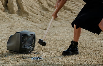 Černé kožené boty, paličkou, rozbíjející se televize, písečná půda, Stará televize, černé šaty, zničení, venkovní scénu, osoba v černé barvě, kladivo, rozbité tv