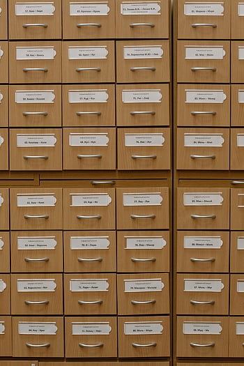 brown drawers, labeled file drawers, wooden file drawers, efficient organization, vertical shot, file organization, drawer labels, storage drawers, office drawers, catalog drawers, file cabinet drawers